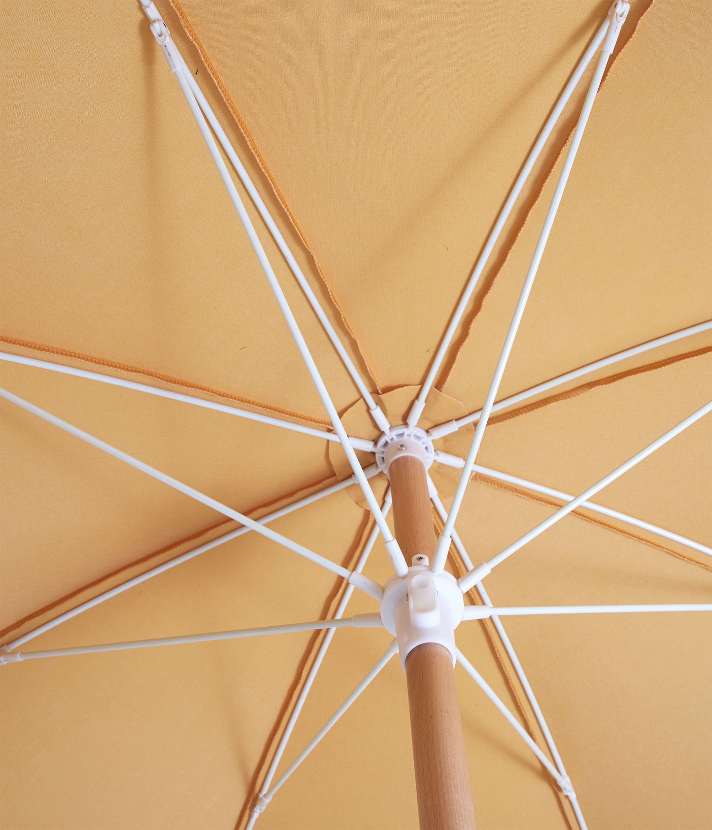 Sunday Supply Co Golden beach umbrella open and seen from underneath.