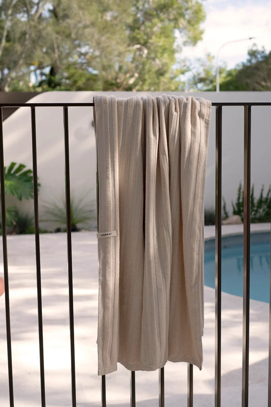 Cream Dunes home towel hanging over a balustrade to dry in the sun