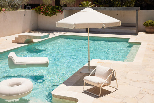 A relaxed summer pool scene styled with Sunday Supply Co. inflatables and towels.