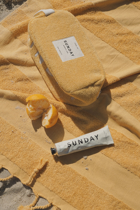 Golden Beach Towel and Natural Mineral Sunscreen by Sunday Supply Co.